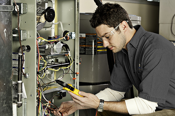 A tech inspecting a furnace