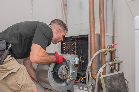 A tech installing a blower in a furnace