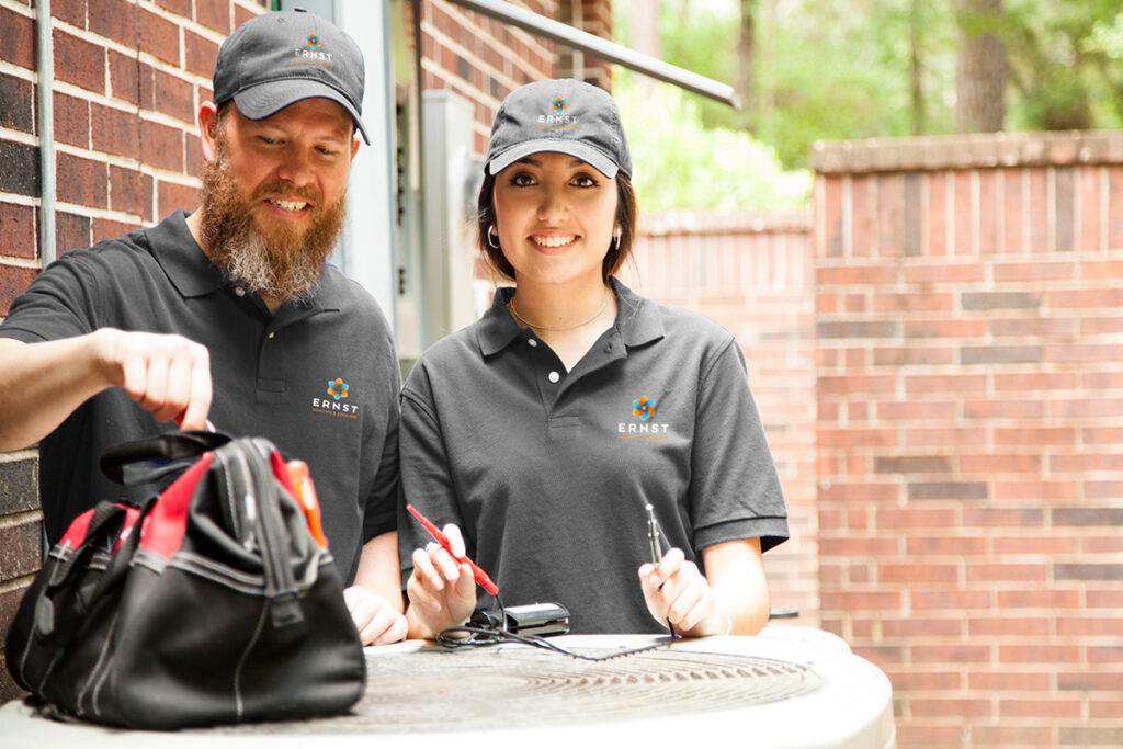 Technicians behind an outdoor HVAC unit