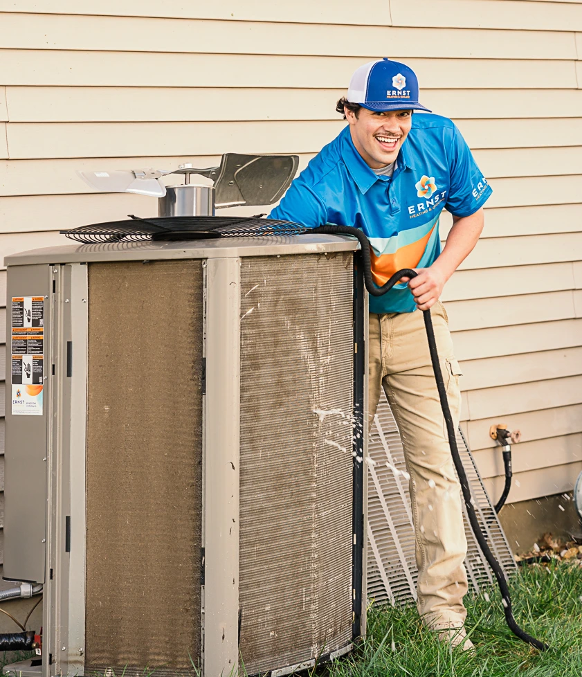 Ernst technician cleaning an outdoor air conditioner unit