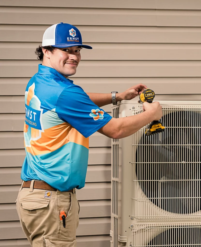 Ernst Heating and Cooling technician working on a heat pump outside