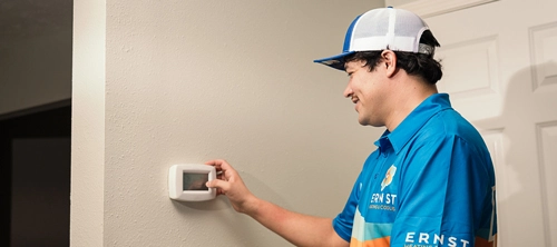 Ernst technician adjusting a thermostat